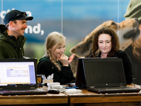 OSPRI team member talking to farmers at Fieldays