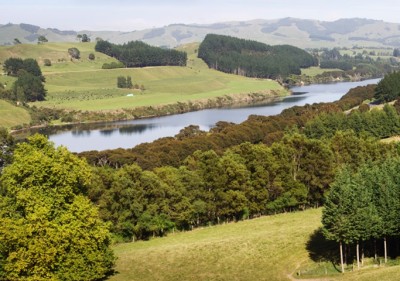 Aerial view of tree-covered hills, sloping down to a river