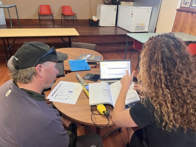 OSPRI regional partner talking to a farmer at a desk