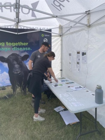 OSPRI regional partner talking to a young farmer, pointing at content on a desk